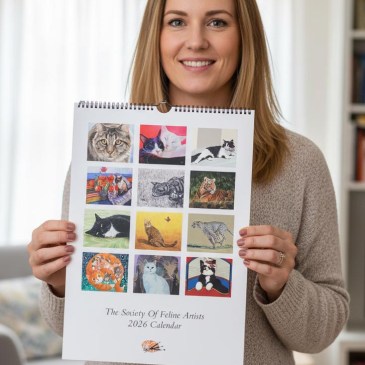 a woman holding a 2026 cat art calendar