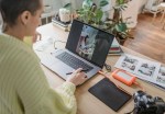 A woman sitting at her desk using a laptop. Image via Pexels